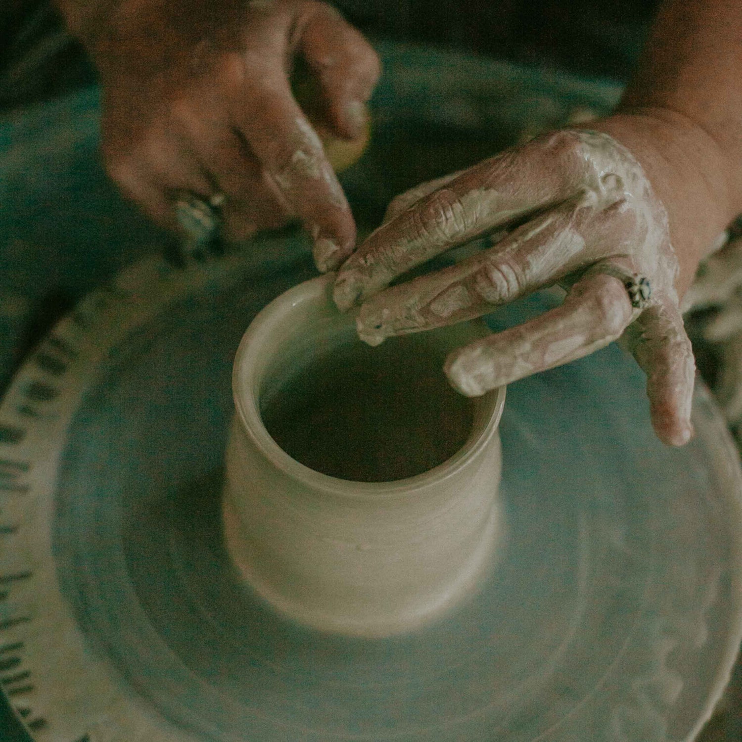 Image of Hayley's hands creating a handthrown pottery mug on a pottery wheel in her studio in Roleystone, Perth Western Australia