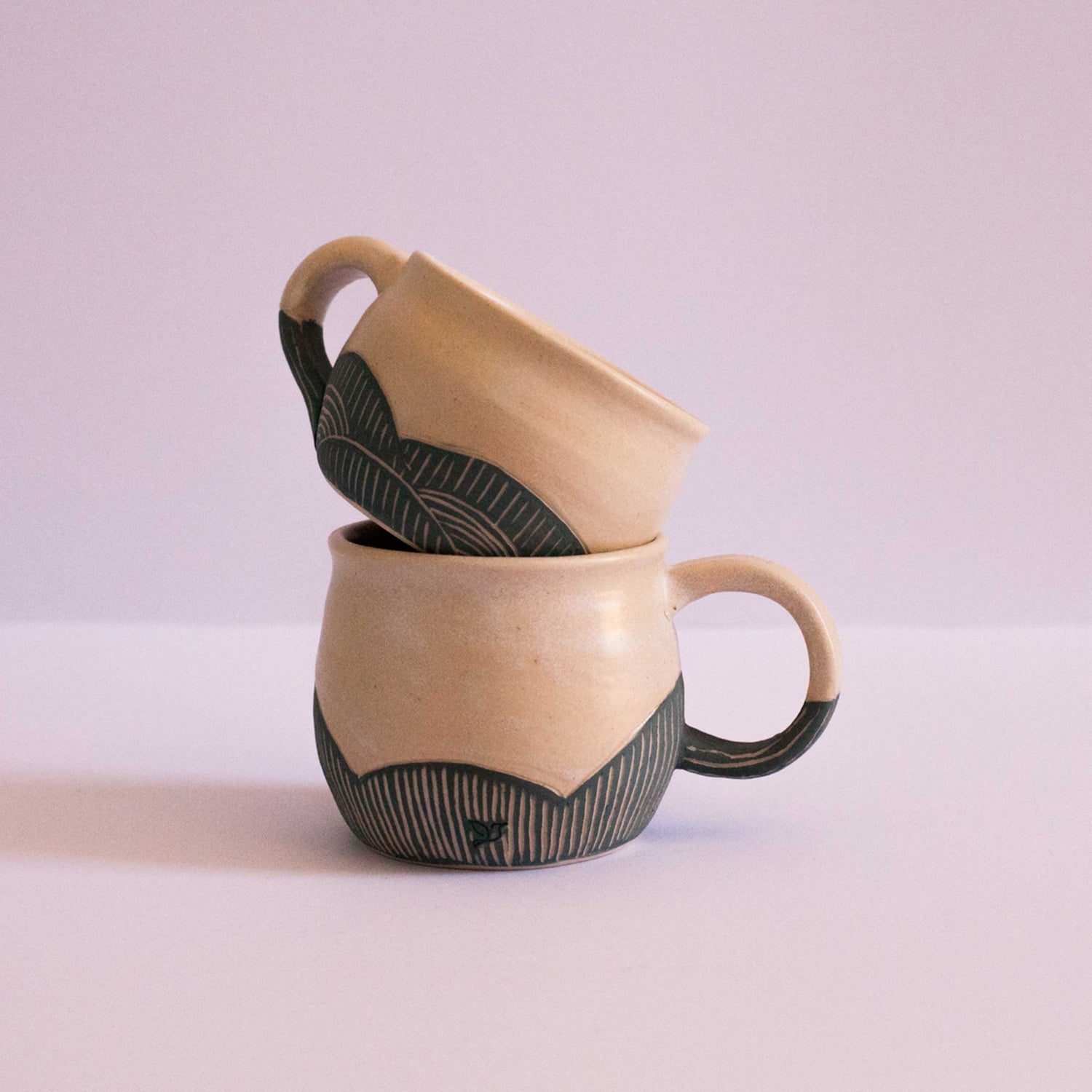 Two handmade Earth and Nectar mugs stacked inside one another