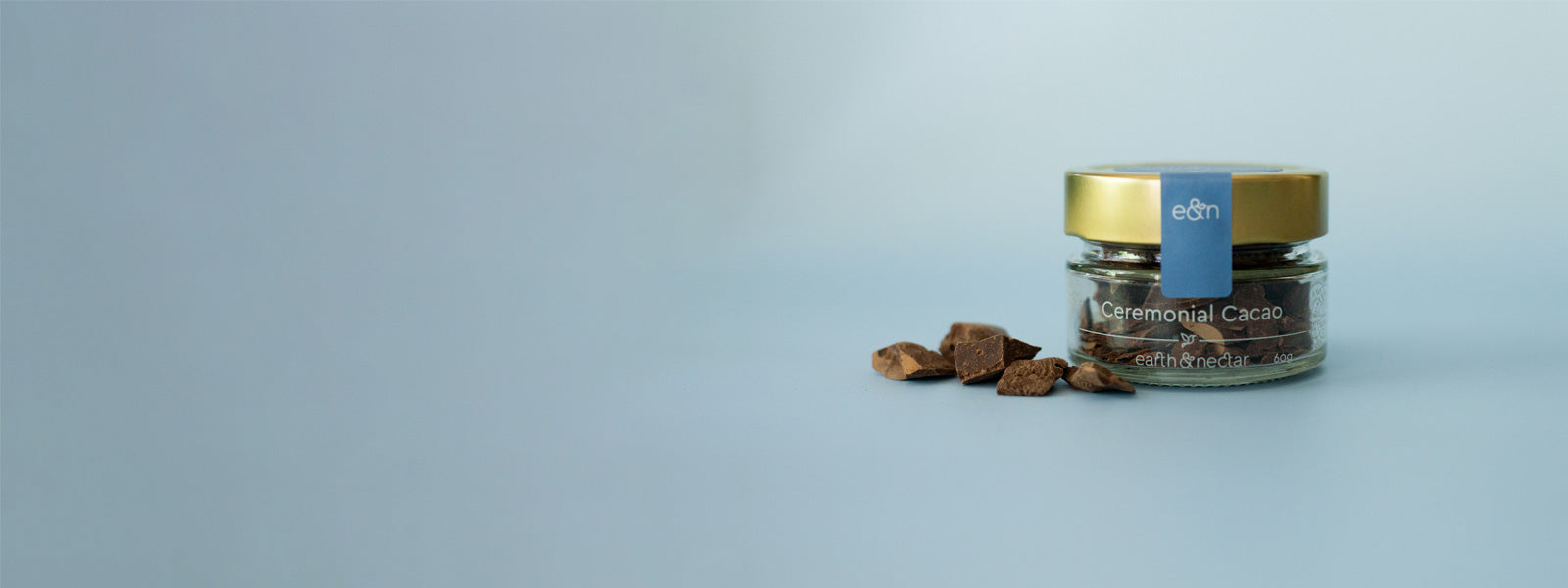 a banner image featuring a sample size jar filled with Earth and Nectar's ceremonial cacao, with chunks of ceremonial cacao placed by the side of the jar