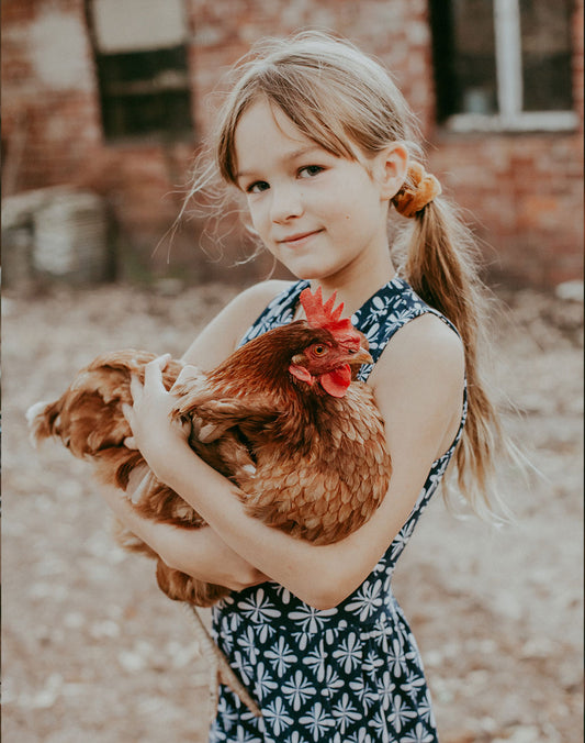 Alice, Hayley's daughter holds one of their chickens on their farm in Roleystone, Perth Western Australia
